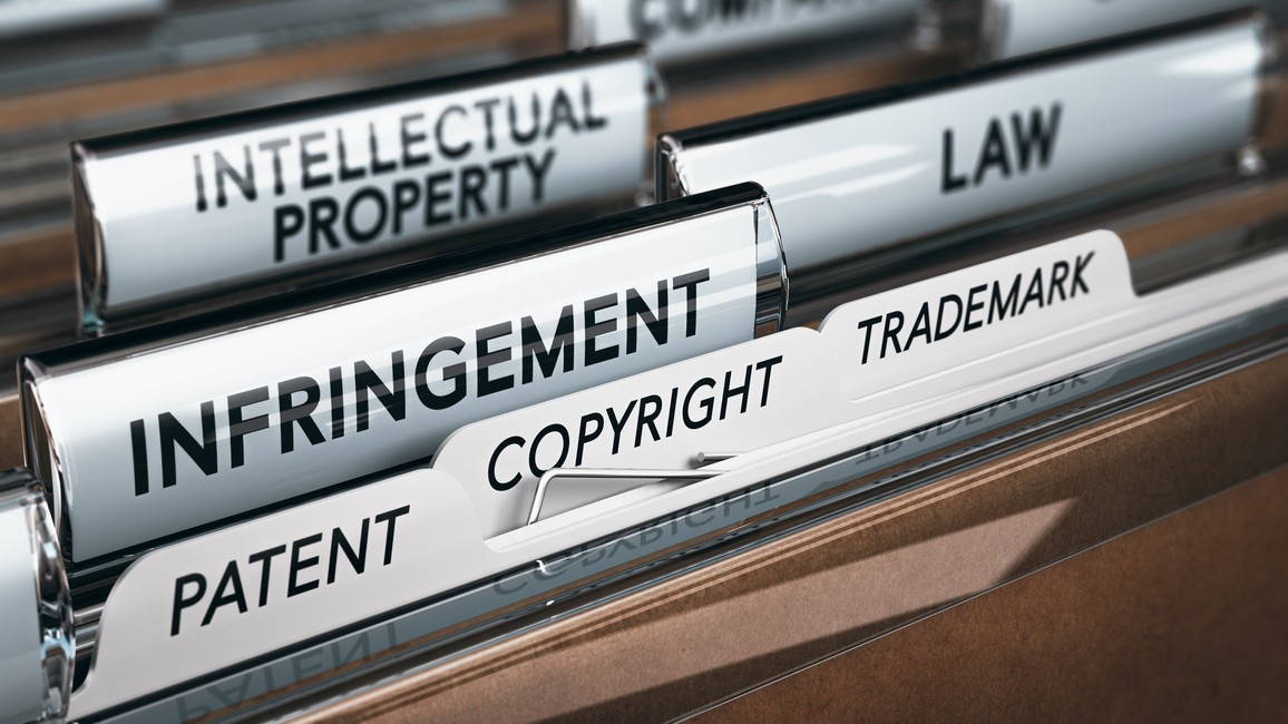 Es sind mehrere Aktenmappen mit Reitern zu sehen. Die Aktenreiter tragen die Aufschriften „intellectual property“, „law“, „infringement“, „trademark“, „copyright“ und „patent“.